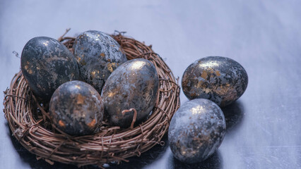 Easter card with a copy of the place for the text. Very Peri 2022 .Purple, blue eggs in a basket on a dark newspaper background. Natural dye karkade tea.