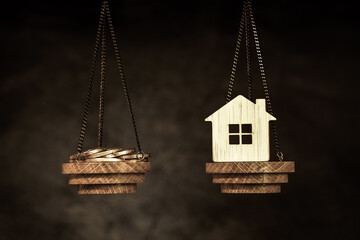 The scales with the coins and the bamboo house. The concept quotes of purchasing housing, credit, and as well as an increase in the cost of utility payments during the sanctions period