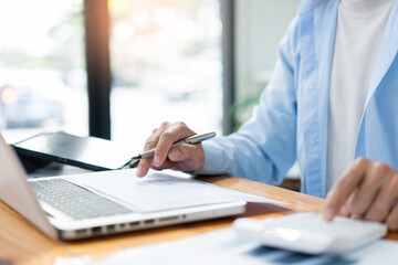 Fototapeta premium Business analyst concept the male accountant concentrating on sale detail while pressing his calculator
