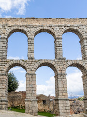 aqueduct of Roman antiquity in Segovia with tourists walking under its arches in Segovia