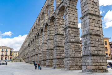 aqueduct of Roman antiquity in Segovia with tourists walking under its arches in Segovia