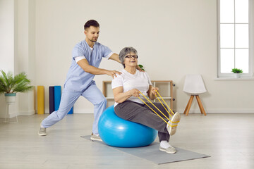 Male physiotherapist do exercises workout with elderly woman patient in physio medical clinic. Therapist doctor help old grandmother recover after injury or trauma. Mature rehabilitation.