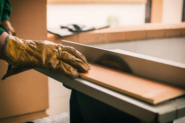 Hands Of A Man Making Custom Furniture Wood Parts On Machine Tool Called Table Saw In Woodworking Shop. Wood Production Concept. Detail