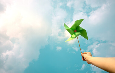 ESG and Clean Energy Concept. Hand Raise up a Wind Turbine Paper into the Sky. Decrease Carbon and...