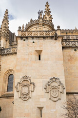 views of the gothic and renaissance cathedral of Segovia with tourists walking under its arches in Segovia