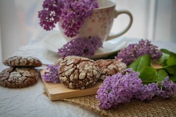 Obraz na płótnie Canvas Romantic and artistic still life porcelain cup with lilac and chocolate biscuits