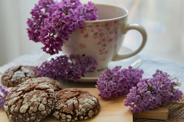 Romantic and artistic still life  porcelain cup with  lilac and chocolate biscuits