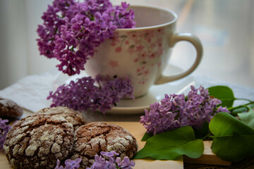 Romantic and artistic still life  porcelain cup with  lilac and chocolate biscuits
