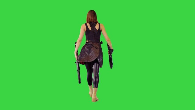 Cyberpunk girl in black military clothes walks with machine guns in hands on a Green Screen, Chroma Key.
