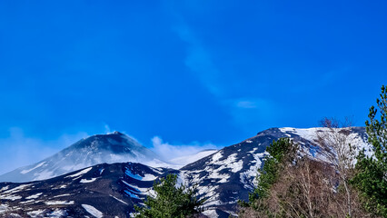 Panoramic view on snow capped and smoking volcano mount Etna on Sicily, Italy, Europe. Solidified...