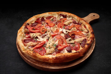 Pizza with chicken, mushrooms, sausage, meat and tomatoes