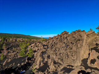 Solidified lava, ash, pumice fields on erupted Sartorio crater. Landscape with dark volcanic sand...