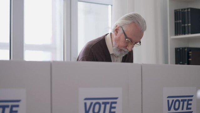 Elderly male citizen voting at polling station, democratic elections, liberty