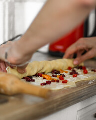 close up of a person working on a kitchen. Woman making dough. Raisins  on the dough