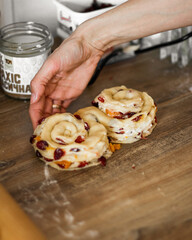hands of a person preparing a dough. close up of a person working on a kitchen. Woman making dough. Raisins  on the dough