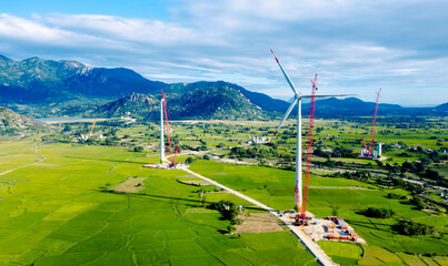 Aerial view of wind turbine under construction with a crane to generate sustainable alternative energy to reduce global warming and climate change. Sustainable growth.
