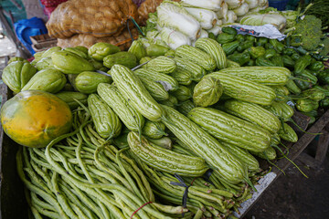 Vegetables at the traditional market. Long beans, papaya and cabbage.