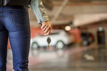 Close up photo of woman hand and car keys.