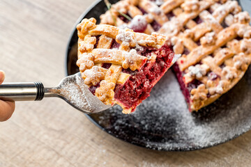 Piece of cherry pie decorated with icing sugar.