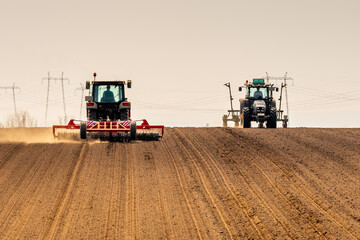 Tractor at agricultural farm field cultivating land