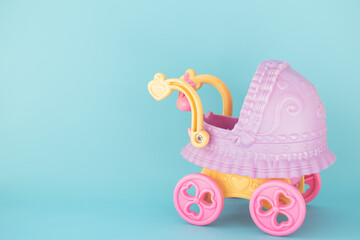 Toy stroller for a baby on a blue background. Congratulations on the birth of a child. Kids toys. A toy shop. Horizontal background.