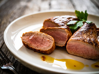 Roasted pork loin on wooden table
