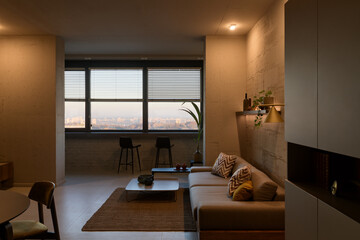Living room in loft style, apartment with open plan loft style, evening lighting in the living room