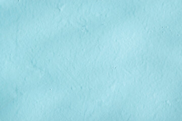 The texture of the surface of a blue concrete wall with shadows, cement pattern with cracks on the background with space to copy