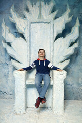 Child sitting on blue throne