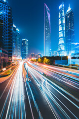 Buildings in the night view of the city and cars driving on the expressway