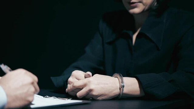 Nervous woman in handcuffs answering police questions, crime investigation