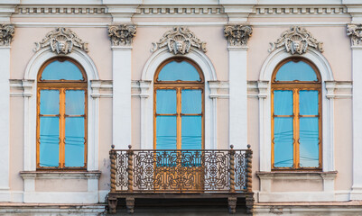 Balcony and three windows in a row on the facade of the urban historic apartment building front view, Saint Petersburg, Russia
 - obrazy, fototapety, plakaty