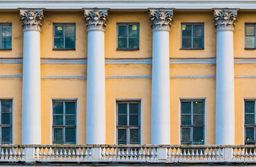 Columns and many windows in a row on the facade of the urban historic apartment building front view, Saint Petersburg, Russia
