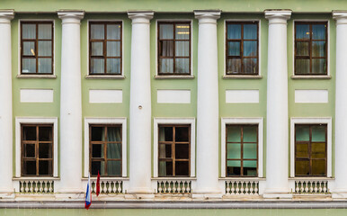Obraz premium Columns and many windows in a row on the facade of the urban historic apartment building front view, Saint Petersburg, Russia 