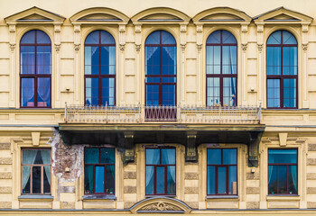 Balcony and many windows in a row on the facade of the urban historic apartment building front view, Saint Petersburg, Russia
