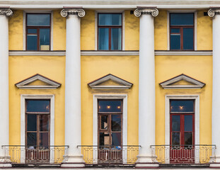 Obraz premium Columns and several windows in a row on the facade of the urban historic apartment building front view, Saint Petersburg, Russia 
