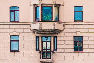 Bay window and several windows in a row on the facade of the urban historic apartment building front view, Saint Petersburg, Russia
