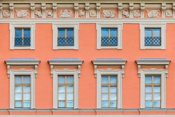 Several windows in a row on the facade of the urban historic apartment building front view, Saint...