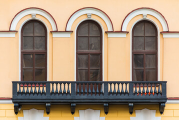 Balcony and three windows in a row on the facade of the urban historic apartment building front view, Saint Petersburg, Russia  © dr_verner