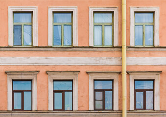 Several windows in a row on the facade of the urban historic apartment building front view, Saint Petersburg, Russia
