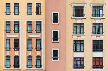Fototapeta premium Many windows in a row on the facade of the modern urban apartment building front view, Krasnaya Polyana, Sochi, Krasnodar Krai, Russia 