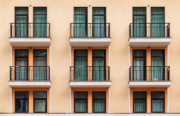 Many balconies and windows in a row on the facade of the modern urban apartment building front view, Krasnaya Polyana, Sochi, Krasnodar Krai, Russia
