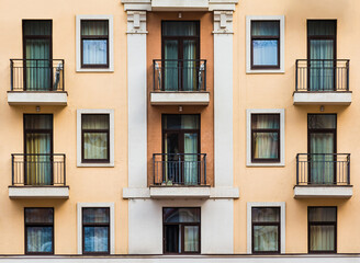 Fototapeta na wymiar Many balconies and windows in a row on the facade of the modern urban apartment building front view, Krasnaya Polyana, Sochi, Krasnodar Krai, Russia 