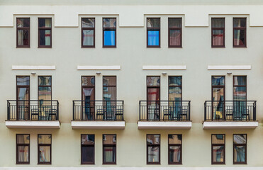 Obraz premium Several balconies and many windows in a row on the facade of the modern urban apartment building front view, Krasnaya Polyana, Sochi, Krasnodar Krai, Russia 