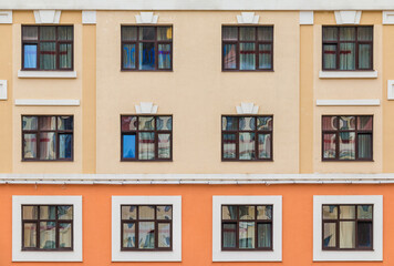 Fototapeta premium Many windows in a row on the facade of the modern urban apartment building front view, Krasnaya Polyana, Sochi, Krasnodar Krai, Russia 