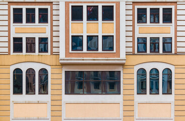 Fototapeta premium Many windows in a row on the facade of the modern urban apartment building front view, Krasnaya Polyana, Sochi, Krasnodar Krai, Russia 