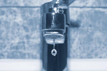 Faucet and falling water drop close up