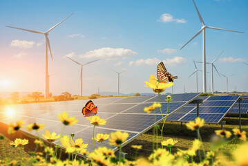Solar power generation plant with a focus on solar panels with flowers and butterfly in the foreground. Concept of conservation of nature and the environment.