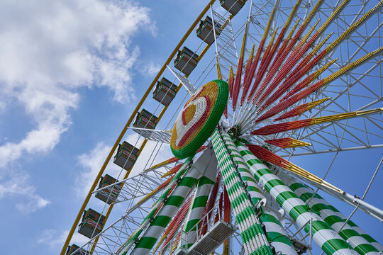 Giant wheel of cannstatter spring festival (Fr&uuml;hlingsfest) 2022. Part of the construction in front of blue cloudy sky.