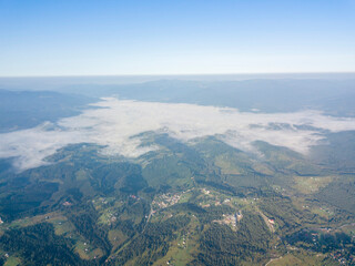 Fototapeta na wymiar High flight in the mountains of the Ukrainian Carpathians. Fog in the valley. Aerial drone view.